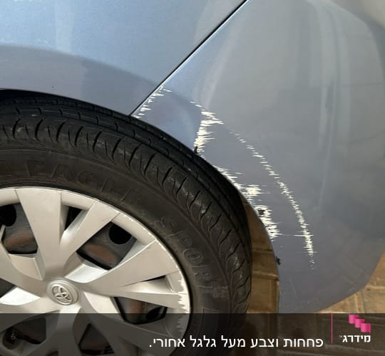 שריטות על פגוש רכב כחול ליד גלגל אחורי